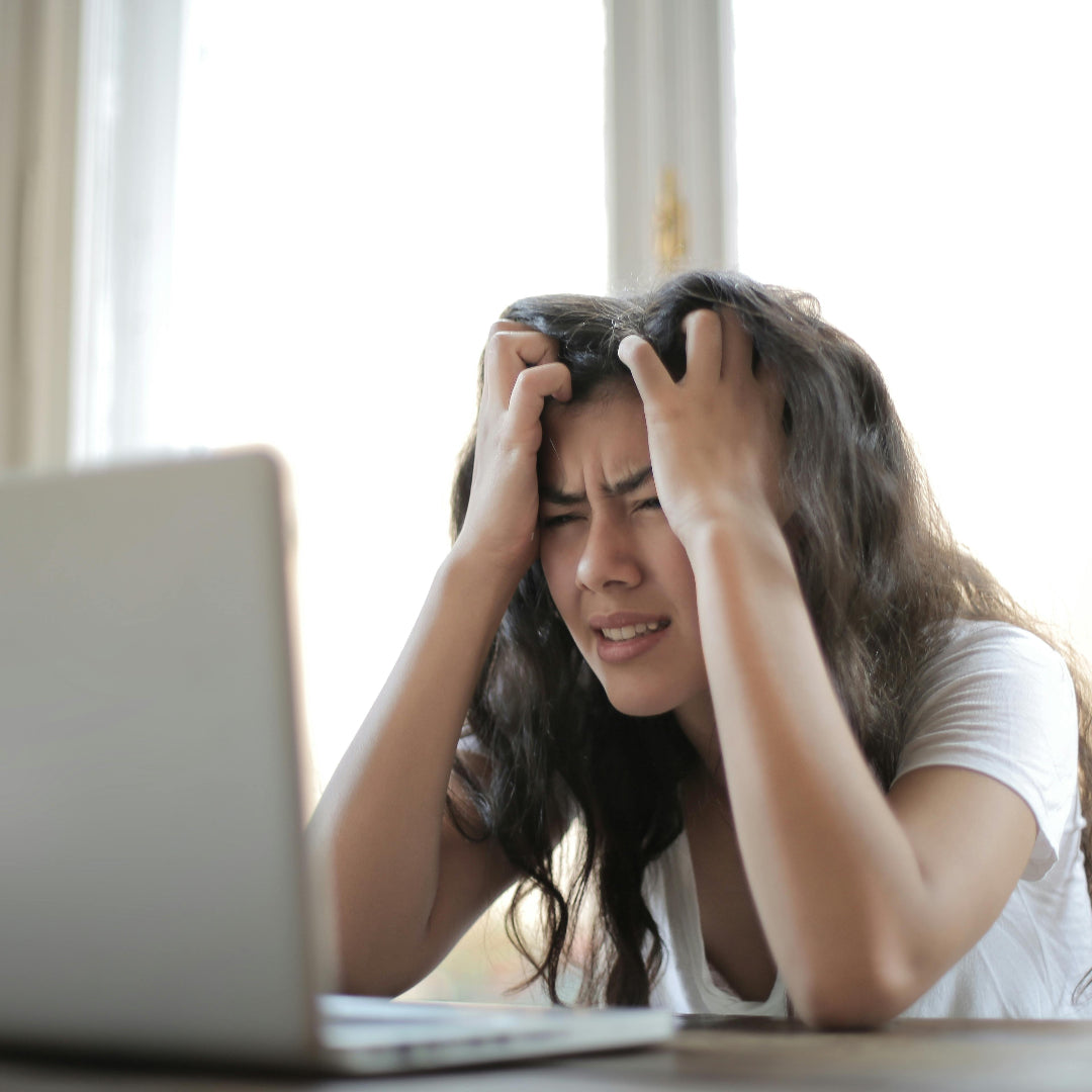 Woman with stress or frustration in front of a laptop