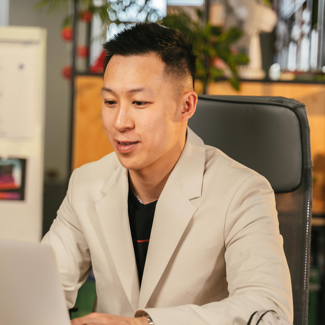 Man sitting at a desk with a laptop in an office setting